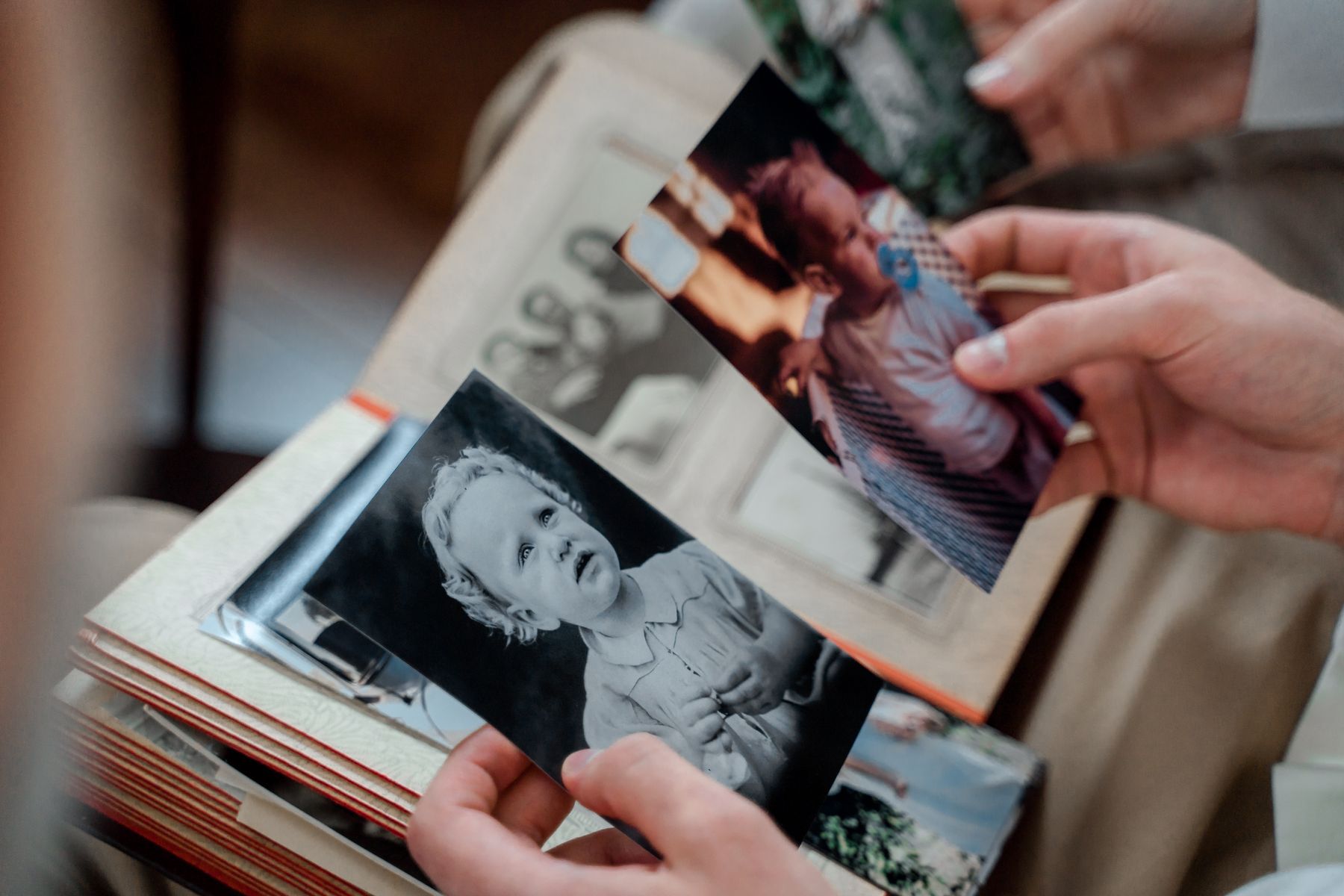 Hands moving through a collection of old family photographs