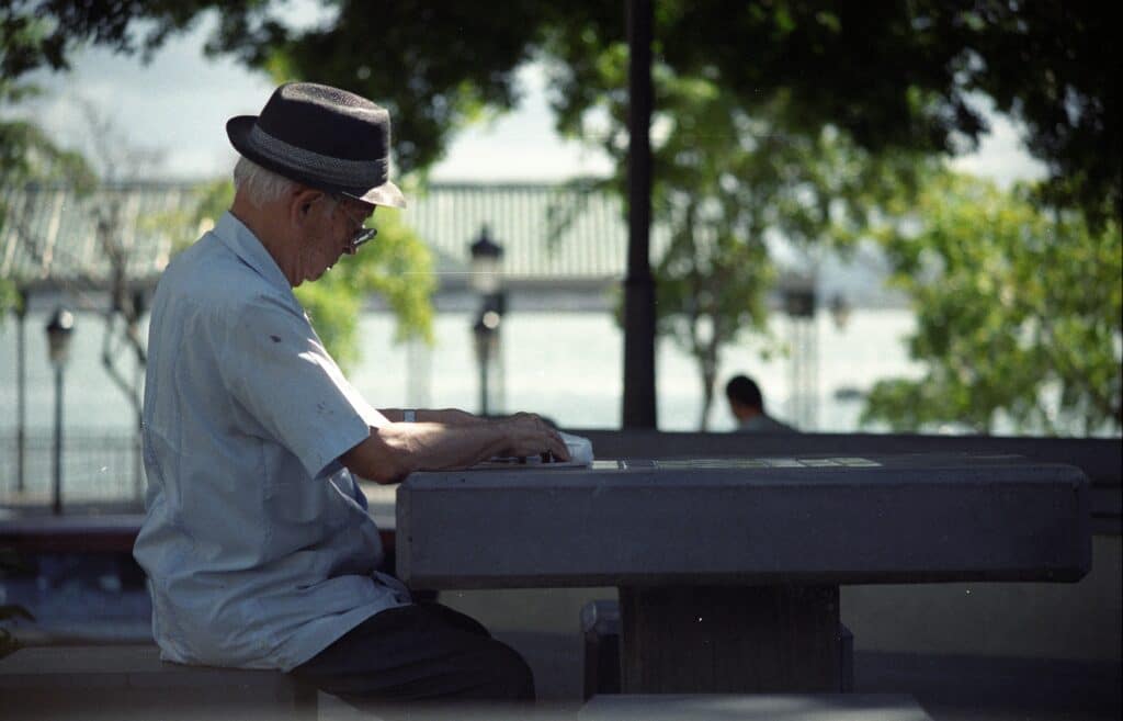 Senior citizen reading a book at a park table